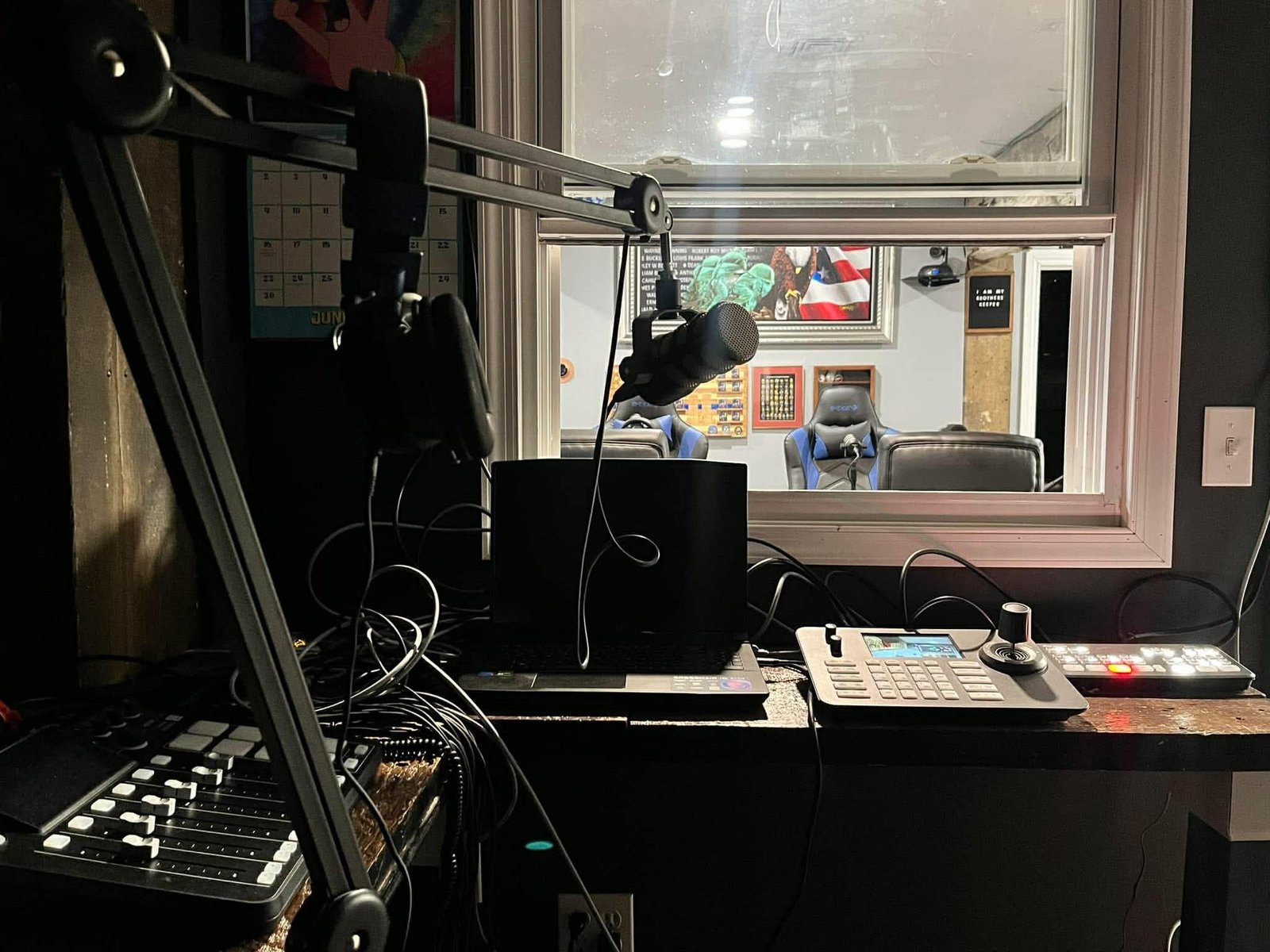 inside the control room looking out to the studio table through a window.