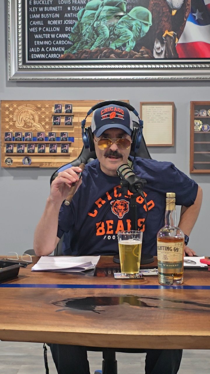 Tommy sitting in a podcast chair with a cigar in his hand.